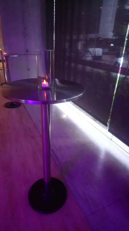 Mesa de coctel con vela y ambientación